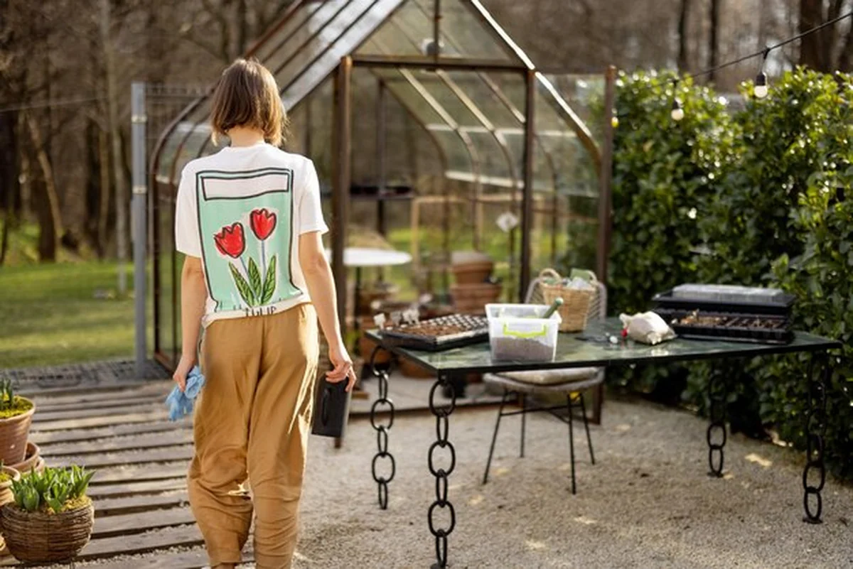 Młoda ogrodniczka dbająca o rośliny na podwórku