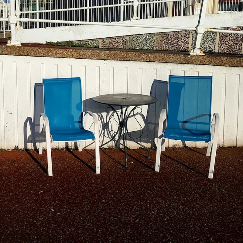 Puste krzesła i stół przy niebieskiej ścianie