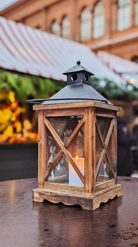 Rustyczna drewniana latarnia z świecą na targu świątecznym podczas Bożego Narodzenia