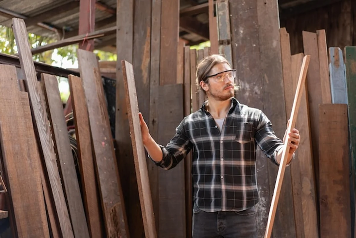 Stolarz wybiera drewno w warsztacie stolarskim