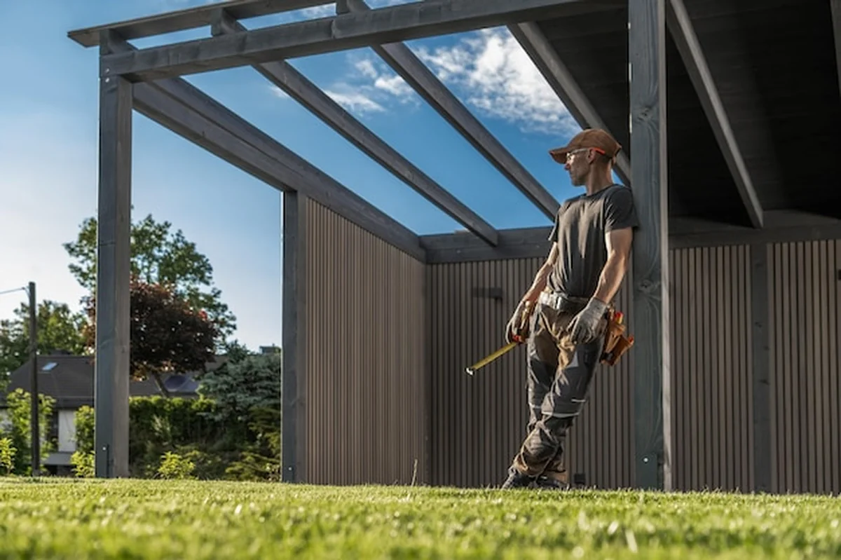 Pracownik budowlany nadzorujący postęp budowy pod niebieskim niebem w ciągu dnia