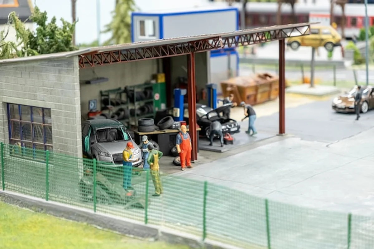 Warsztat naprawy samochodów z mechanikami i narzędziami na otwartej przestrzeni