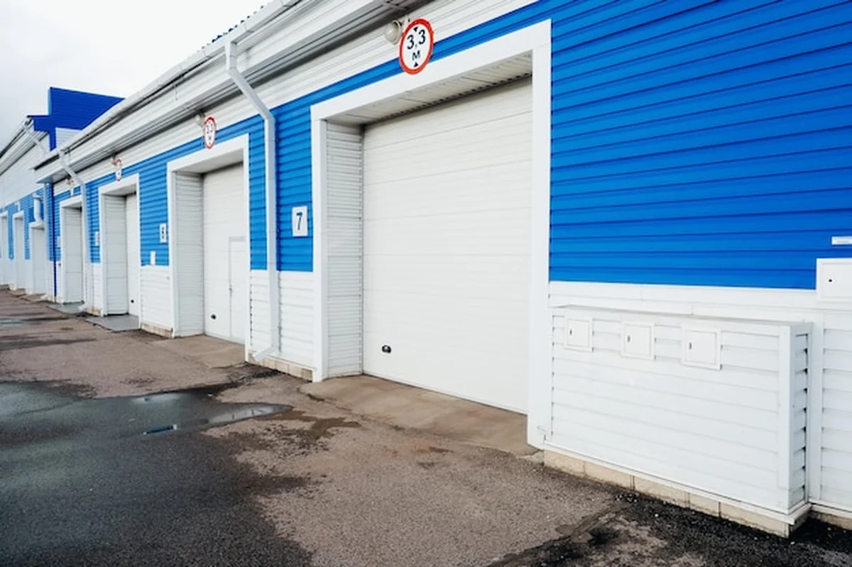 Nowoczesny garaż z automatycznymi bramami dla samochodów ciężarowych i dużych pojazdów. Widok zewnętrzny